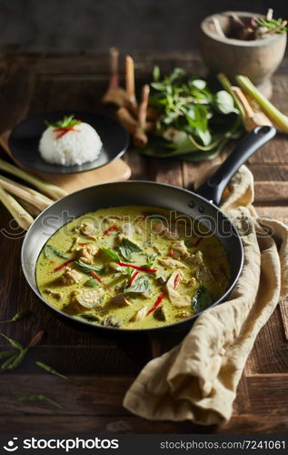 Thai food chicken green curry on wooden background.