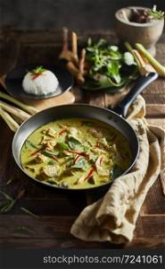 Thai food chicken green curry on wooden background.