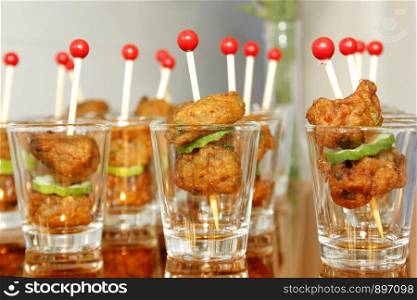 thai food, fried fish-paste balls in small glass on buffet line
