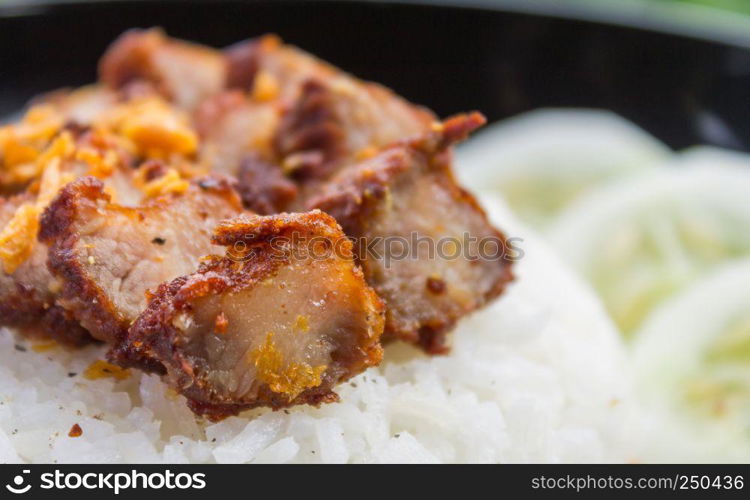 Thai Food Fried Pork with Garlic and Cucumber in Black Dish. Fried pork with garlic or steak on rice and cucumber in food and drink category
