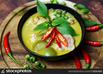 Thai food green curry on soup bowl with ingredient herb vegetable on wooden plate background / green curry chicken cuisine asian food on the table