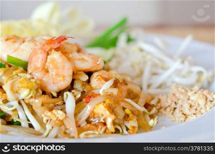 thai food , stir fry noodles with shrimp , egg and fresh vegetable on white dish