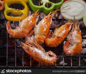 thai fresh water shrimp grilled on barbecue fire stove with chilly and onion ring