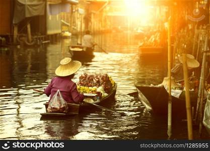 thai fruit seller sailing wooden boat in thailand tradition floating market
