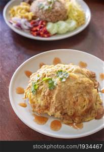 Thai Omelette over steamed rice on plate. Thai Omelette over steamed rice
