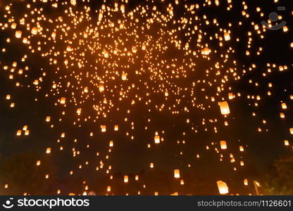 Thai people release sky floating lanterns or lamp to worship Buddha&rsquo;s relics at night. Traditional festival in Chiang mai, Thailand. Loy krathong and Yi Peng Lanna ceremony. Celebration background.