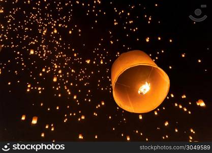 Thai people release sky floating lanterns or lamp to worship Buddha&rsquo;s relics at night. Traditional festival in Chiang mai, Thailand. Loy krathong and Yi Peng Lanna ceremony. Celebration background.