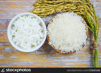 Thai rice white on bowl wooden background / raw and cooked jasmine rice grain with ear of paddy agricultural products for food in Asian