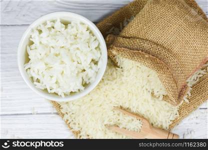Thai rice white on bowl wooden background / raw and cooked jasmine rice grain agricultural products for food in Asian
