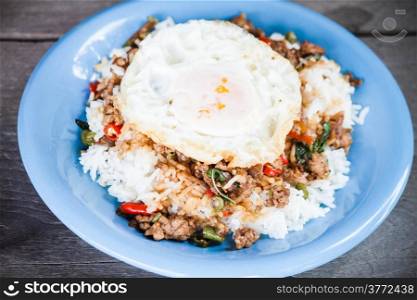 Thai spicy food, rice topped with stir fried pork and basil with fried egg