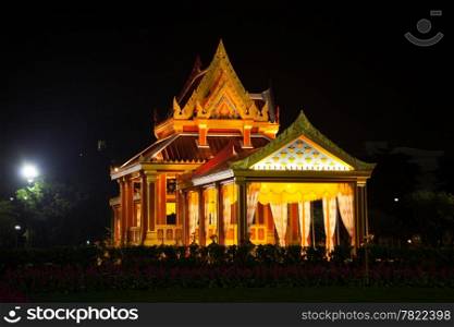 Thai-style building with lights on at night. Thai art, architecture and design.