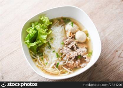 Thai traditional menu food, Noodle soup bowl fresh vegetable lettuce pork and Pork balls on wooden background