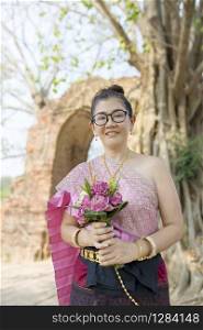 thai woman toothy smiling face standing with pink lotus flower bouquet in hand