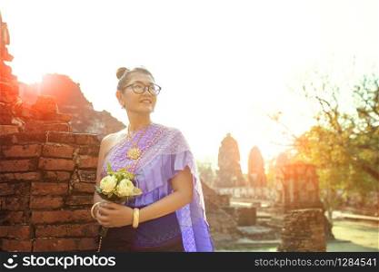 thai woman toothy smiling face standing with pink lotus flower bouquet in hand