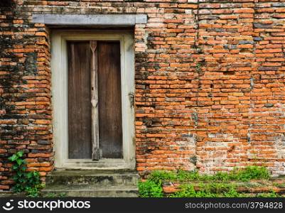 Thai wooden door on brick wall