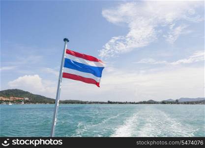 Thailand flag with boat wake at Koh Pha Ngan island
