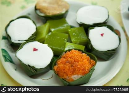 Thailand many types of Dessert cup made ??from banana leaves in a round white dish.