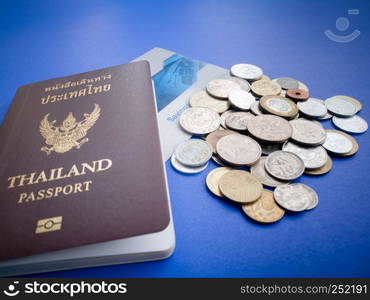 Thailand passport with international coin and saving bank book on the blue background