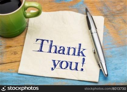 Thank you on a napkin with a cup of coffee against grunge blue painted wood