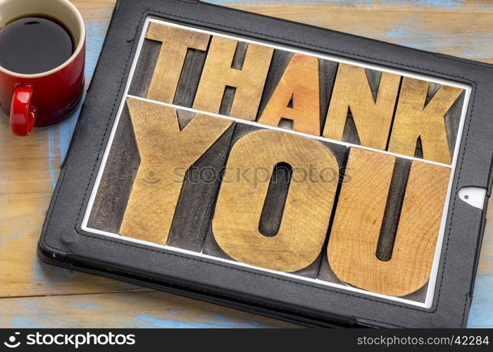 thank you - word abstract in vintage letterpress wood type on a digital tablet with coffee