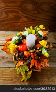 Thanksgiving centerpiece with candle and artificial fall leaves. Thanksgiving centerpiece with candle and artificial fall leaves vertical. Thanksgiving greeting with fall decor. Fall decoration.