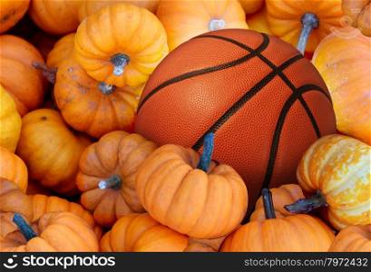 Thanksgiving Day basketball and autumn sports during harvest time with a holiday tournament ball in a pile of orange pumpkins as a concept for living a healthy lifestyle and eating natural food with fitness through exercise.