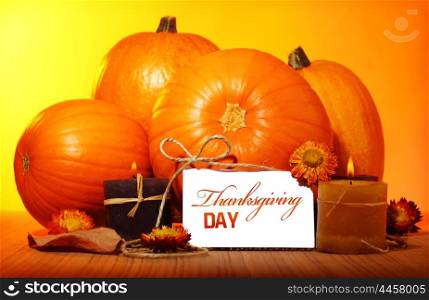 Thanksgiving day decoration for holiday celebration, pumpkin with greeting card on wooden table on yellow background, autumn season concept
