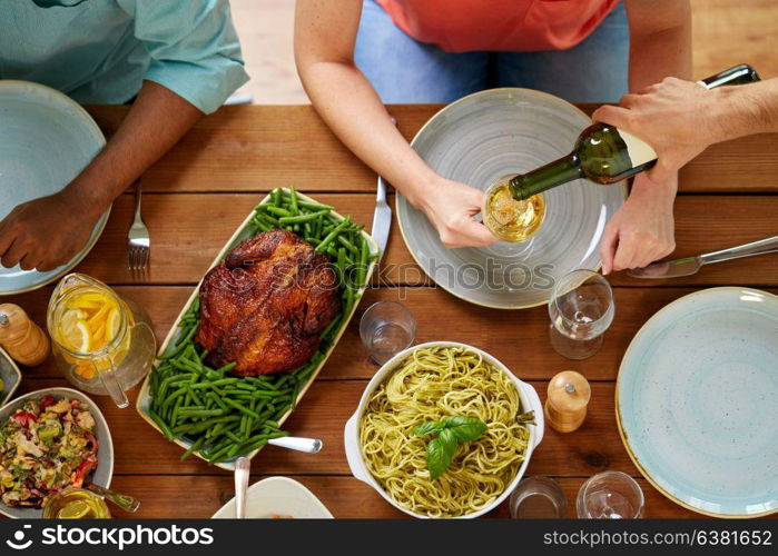 thanksgiving day, eating and leisure concept - group of people having dinner at table with food and drinking wine. group of people eating and drinking wine