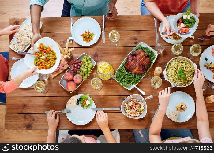 thanksgiving day, eating and leisure concept - group of people having dinner at table with food. group of people eating at table with food. group of people eating at table with food