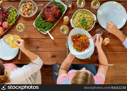 thanksgiving day, eating and leisure concept - group of people having dinner at table with food. group of people eating at table with food