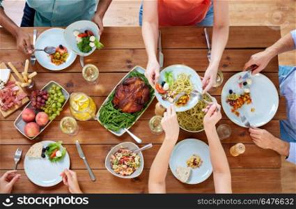 thanksgiving day, eating and leisure concept - group of people having dinner at table with food. group of people eating at table with food. group of people eating at table with food