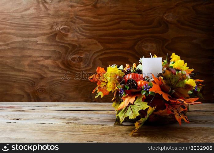 Thanksgiving decoration with silk fall leaves on rustic background. Thanksgiving greeting with fall decor. Fall centerpiece. Thanksgiving background. Copy space.. Thanksgiving decoration with silk fall leaves on rustic backgrou