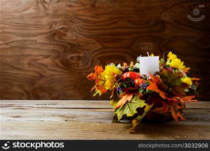 Thanksgiving decoration with silk fall leaves on rustic background. Thanksgiving greeting with fall decor. Fall centerpiece. Thanksgiving background. Copy space.. Thanksgiving decoration with silk fall leaves on rustic backgrou