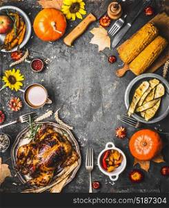 Thanksgiving dinner background with roasted turkey , sauce , pumpkin and dishes of autumn vegetables on rustic background, top view, frame