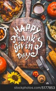 Thanksgiving dinner background with turkey ,sauce,grilled vegetables,corn ,cutlery , pumpkin, fall leaves and text Happy Thanksgiving Day on wooden gutting board, top view.