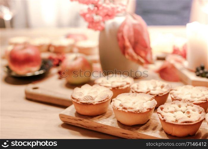 Thanksgiving Fall traditional homemade apple pies on wooden board for autumn holiday dining. Cozy home mood