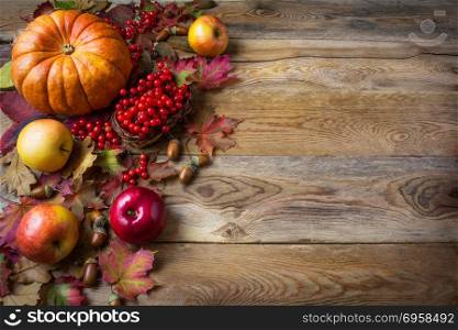Thanksgiving greeting background with pumpkins, apples and fall leaves. Thanksgiving background with seasonal vegetables and fruits. . Thanksgiving greeting background with pumpkins, apples and fall