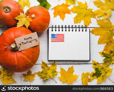 Thanksgiving greeting card on a background of a pattern of the US Flag, ripe pumpkins and autumn leaves. Preparing for the holidays. Congratulations to family, loved ones, friends and colleagues. Thanksgiving greeting card, pumpkins and autumn leaves