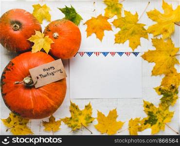 Thanksgiving greeting card on a background of a pattern of the US Flag, ripe pumpkins and autumn leaves. Preparing for the holidays. Congratulations to family, loved ones, friends and colleagues. Thanksgiving greeting card, pumpkins and autumn leaves