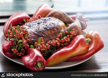 Thanksgiving or Christmas Background of Holiday Turkey on the Plate with Peppers and Berries on a Wooden Table