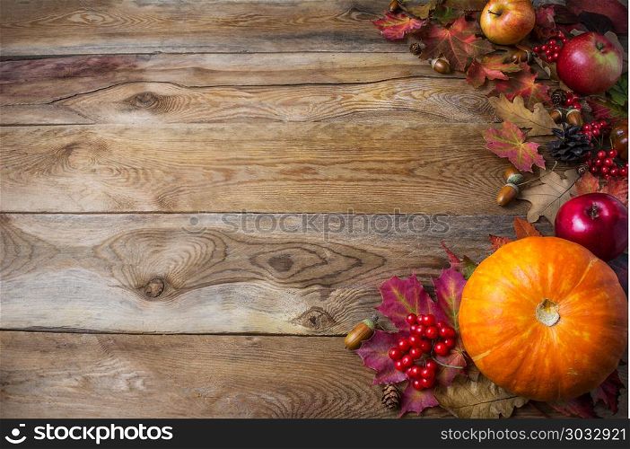 Thanksgiving or fall greeting background with pumpkins and fall leaves. Thanksgiving background with seasonal vegetables and fruits. Fall background. Copy space. Thanksgiving or fall greeting background with pumpkins and fall