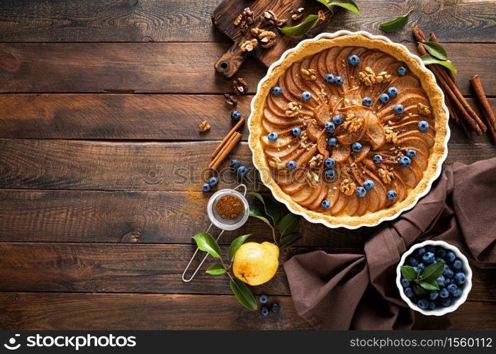 Thanksgiving pear tart, pie or cake with fresh pears and blueberry, cinnamon and walnuts