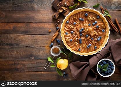 Thanksgiving pear tart, pie or cake with fresh pears and blueberry, cinnamon and walnuts