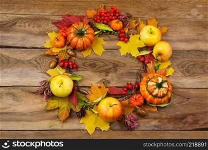 Thanksgiving red, yellow, orange door wreath with pumpkins, apples, berries, acorns and pine cones, copy space