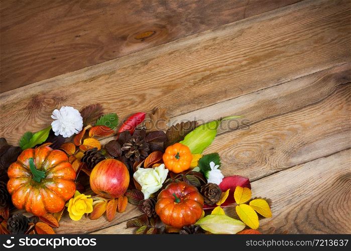 Thanksgiving rustic background with pumpkin, pine cones, apple and flowers wreath, copy space