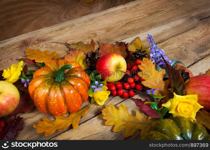 Thanksgiving rustic background with pumpkins, rowan berries and purple flowers wreath, copy space