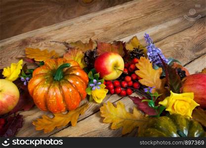 Thanksgiving rustic background with pumpkins, rowan berries and purple flowers wreath, copy space