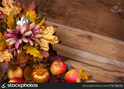 Thanksgiving rustic decor with fall leaves bouquet, golden pumpkin and red apples, copy space
