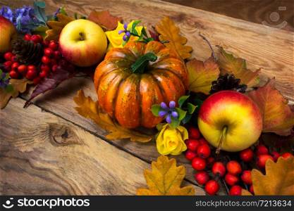 Thanksgiving rustic decor with pumpkin, rowan berries, oak leaves and purple flowers
