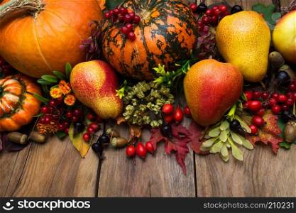Thanksgiving rustic holiday arrangement with pumpkin, oak, pear, fall leaves and berry